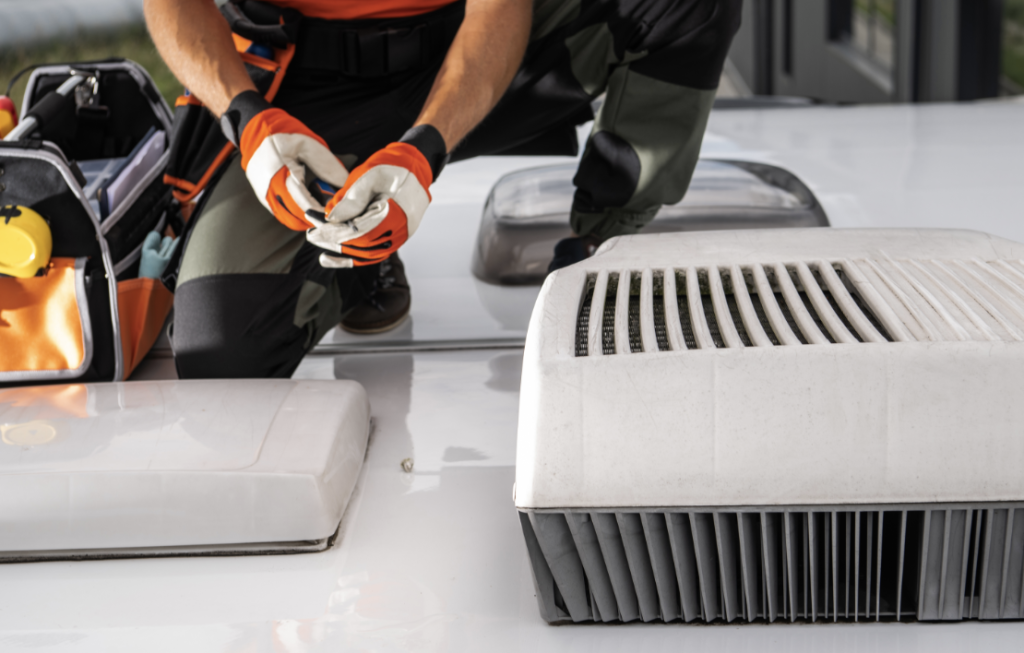 A gloved service technician working on the roof of an RV